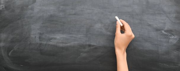 Hand with chalk writing on school blackboard - Foto, imagen