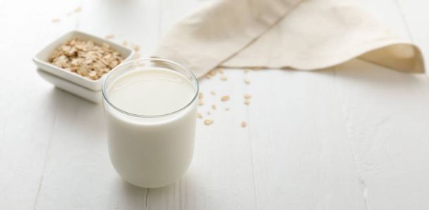 Vaso de sabrosa leche de avena sobre mesa blanca
 - Foto, imagen