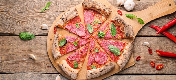 Gustosa pizza piccante affettata su fondo di legno - Foto, immagini