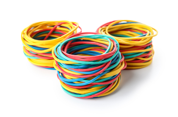 Three stacks of colorful rubber bands on white background - Foto, immagini