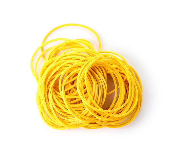 Heap of yellow rubber bands isolated on white background - 写真・画像