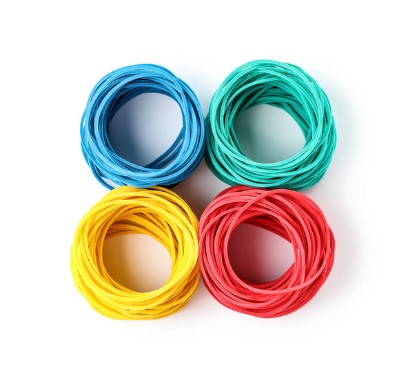 Stacks of elastic rubber bands on white background - Fotoğraf, Görsel