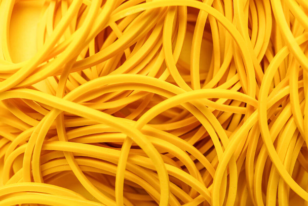 Yellow rubber bands as background, closeup - Foto, afbeelding