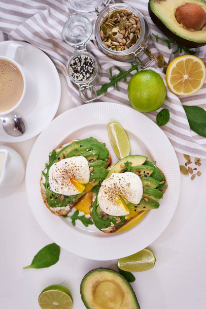 Freshly made poached egg and Avocado toasts on light grey background. - Fotó, kép