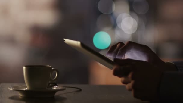 man met behulp van tablet pc en koffie drinken in café - Video