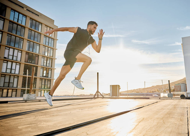 Shot of a sporty young man out on a rooftop for a workout. - Zdjęcie, obraz