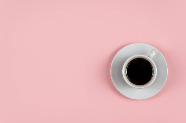 Espresso coffee against a pink background. White cup and saucer. Hot drink. Copy space for text and design elements. - Foto, Imagem