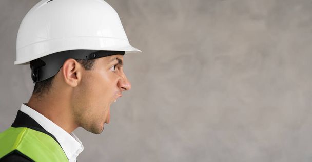 Young arab architect inspector man wearing builder safety helmet frustrated shouting with anger, crazy and yelling, anger concept. Banner, free space - Foto, immagini