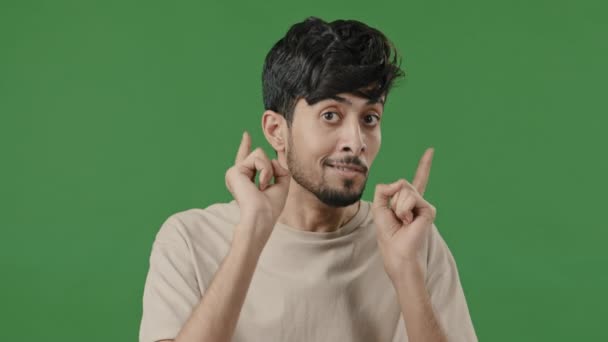 Smiling arab man showing hey you hand gesture approve good idea respect sign pretending shooting pistols making choice positive hindu guy boyfriend show consent approval symbol stands in green studio - Filmmaterial, Video