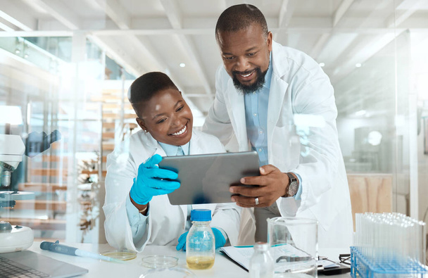 Shot of two scientists using a digital tablet in a laboratory. - Foto, Imagen