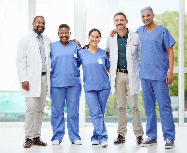 Постріл веселої групи лікарів, що стоять на руках один навколо одного всередині лікарні протягом дня
. - Фото, зображення