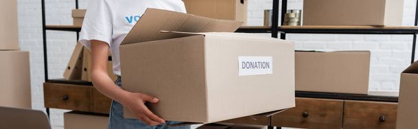 cropped view of african american volunteer holding donation box in charity center, banner - Photo, Image