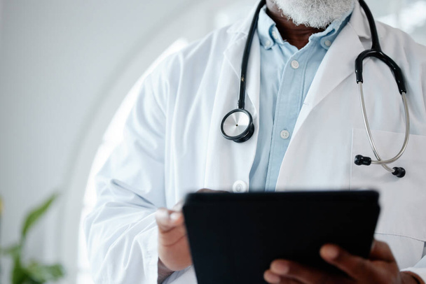 Closeup shot of an unrecognisable doctor using a digital tablet in a medical office. - Fotografie, Obrázek