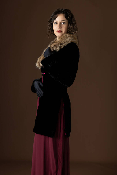 A 1920s woman wearing a black velvet coat with a fur collar - Zdjęcie, obraz