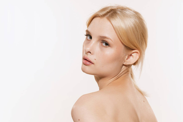 Well-kept skin. Young beautiful girl with blond glossy hair and without makeup isolated on white studio background. Youth, spa, cosmetics, beauty and skin care concept. Copy space for ad - Zdjęcie, obraz