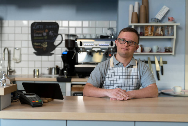 Portrait of caucasian man with down syndrome working in the cafe - Photo, Image
