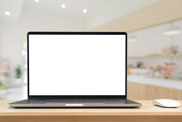 Laptop z czystym ekranem na drewnianym stole z kawiarni rozmyte tło - Zdjęcie, obraz