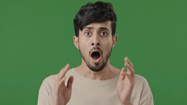 Primer plano retrato de árabe hombre asustado cara india hombre expresando choque boca abierta sensación estrés horror gritando de miedo malas noticias guapo indio chico con wow reacción posando sobre fondo verde - Metraje, vídeo