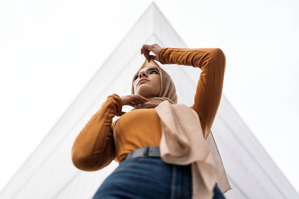 Beautiful young muslim woman wearing hijab standing against white background and looking to the side. - Fotografie, Obrázek