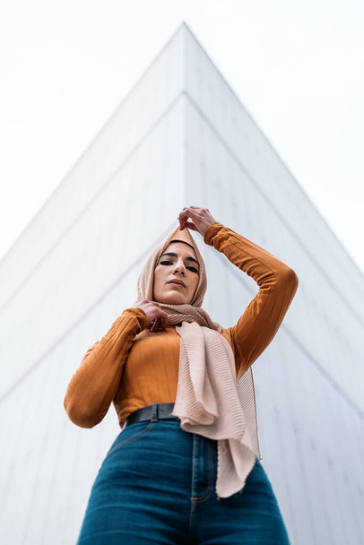Beautiful young muslim woman wearing hijab standing against white background and looking at camera. - Valokuva, kuva