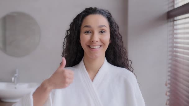 Female portrait young happy hispanic woman client standing in bathroom or beauty parlor smiling showing thumb up gesture approval great result beautiful girl advertises recommends cosmetology service - Materiał filmowy, wideo