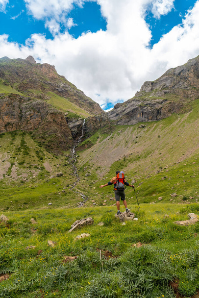 A young man visiting the Salto de Tendenera Waterfall in the Pyrenees in the Ripera Valley, Huesca - 写真・画像