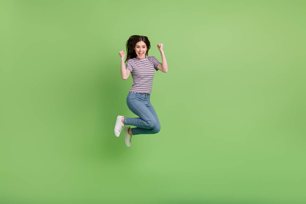 Full length body size view of attractive cheerful lucky girl jumping having fun rejoicing isolated on bright green color background. - Φωτογραφία, εικόνα
