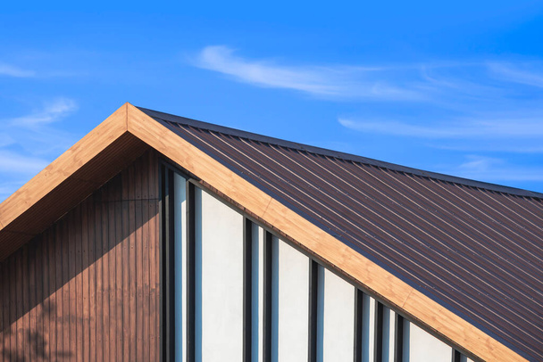 Toit à pignon en bois avec lamelles décoration de maison vintage contre les nuages sur fond bleu ciel - Photo, image