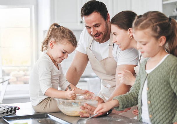 Aufnahme einer Familie beim gemeinsamen Backen in der Küche. - Foto, Bild