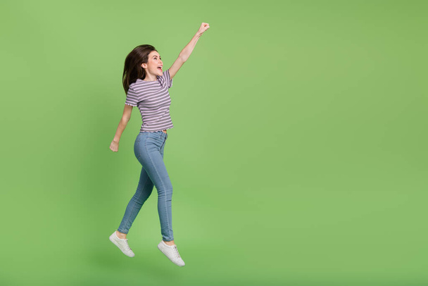 Full length body size view of attractive cheerful girl jumping striving copy space isolated on bright green color background. - Zdjęcie, obraz