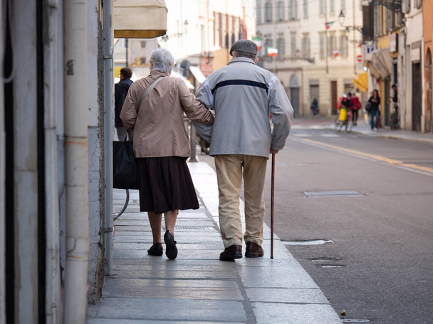 Een paar oudere mannen en vrouwen die samen wandelen in het stadscentrum. - Foto, afbeelding