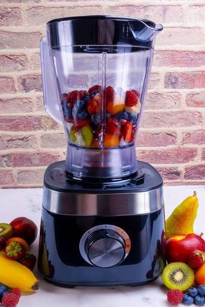 Fresh fruit smoothie in blender. Preparing a fresh drink full of vitamins for a healthy diet. - Photo, Image