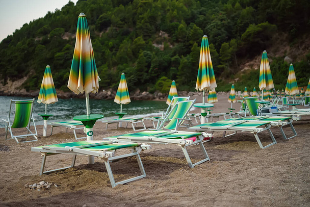 Ξαπλώστρες και ομπρέλες στην ιδιωτική παραλία. - Φωτογραφία, εικόνα