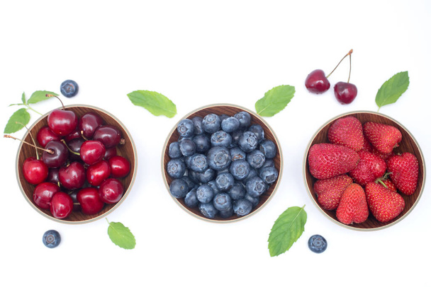 Blueberries, strawberries and cherry on white background with free space. - Fotó, kép