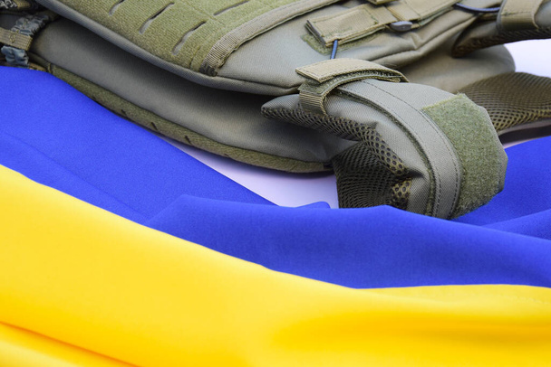 Armatura tattica militare con targhe sullo sfondo della bandiera ucraina. Il concetto di proteggere il corpo dagli spari nella guerra in Ucraina. - Foto, immagini