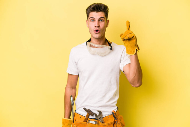 Молодий електрик кавказький чоловік ізольований на жовтому тлі має якусь чудову ідею, концепцію творчості
. - Фото, зображення