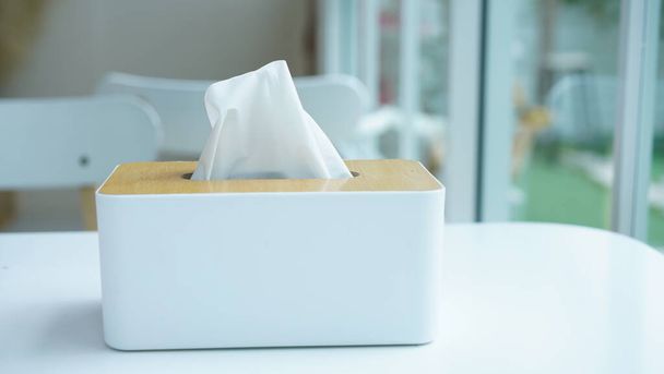 Tissue paper in napkin paper wooden white box on table. White sheet paper for cleaning face. Disposable cloth as hygienic. - Foto, Bild