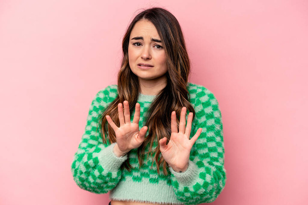 Young caucasian woman isolated on pink background rejecting someone showing a gesture of disgust. - Photo, Image