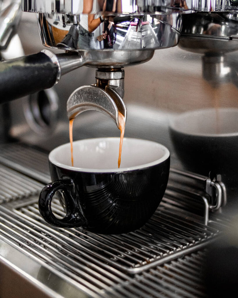 Виготовлення кави з кавоварки в кафе. Чорна чашка капучино
. - Фото, зображення
