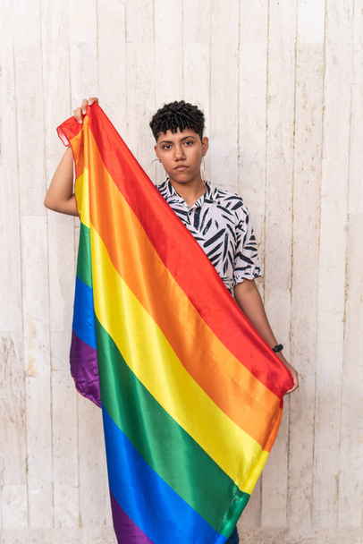 Молодая женщина с флагом гей-гордости в поддержку гей-прайда на улице. - Фото, изображение