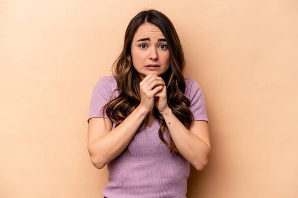 Young caucasian woman isolated on beige background scared and afraid. - Foto, imagen