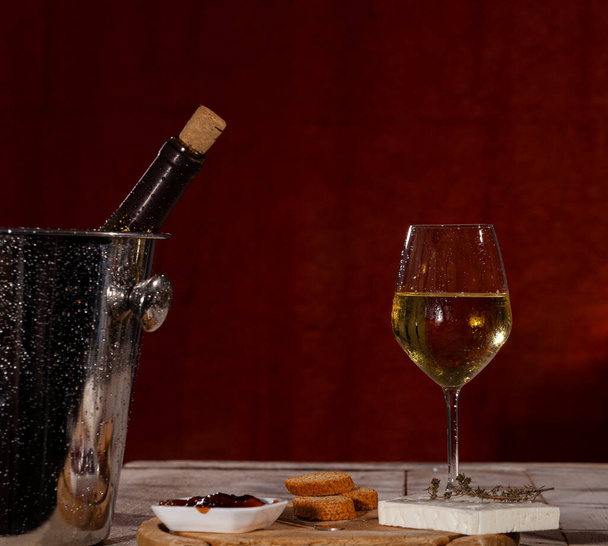 Πεντανόστιμο ορεκτικό με φέτα και μαρμελάδα που σερβίρεται με φρέσκο λευκό κρασί - Φωτογραφία, εικόνα