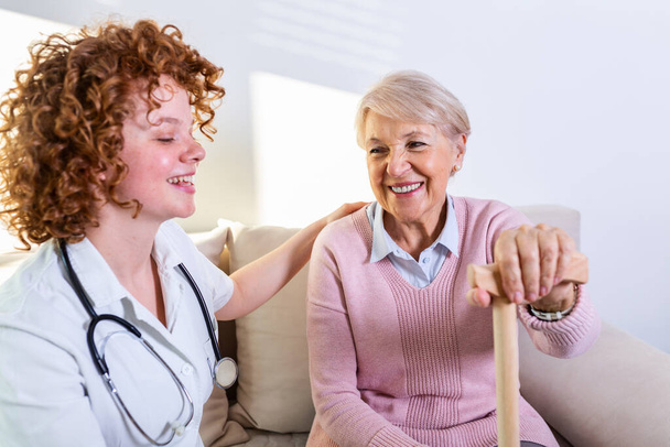 Stretta relazione positiva tra paziente anziano e caregiver. Donna anziana felice che parla con un badante amichevole. Giovane bella badante e donna felice più anziana - Foto, immagini