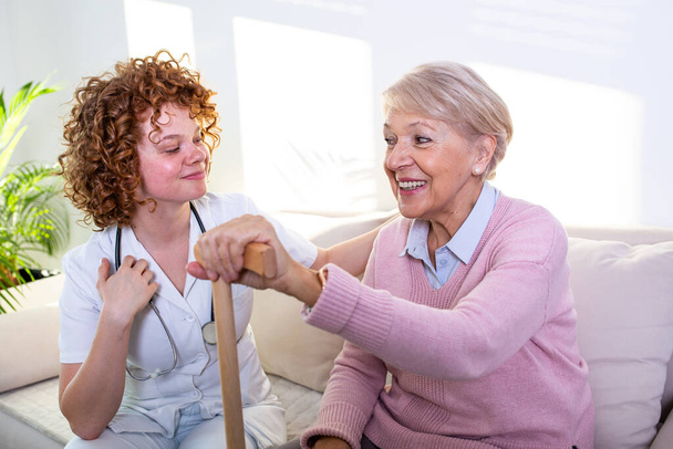 Close positive relationship between senior patient and caregiver. Happy senior woman talking to a friendly caregiver. Young pretty caregiver and older happy woman - Zdjęcie, obraz