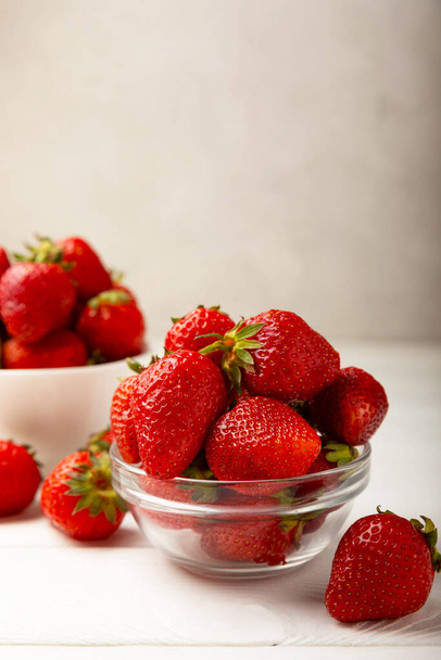 Frische reife Erdbeeren in einem Teller auf weißem Holzhintergrund.Vegetarische Bio-Beeren.Gesundes Lebensmittel.Vitamin.Kopierplatz.Platz für Text - Foto, Bild
