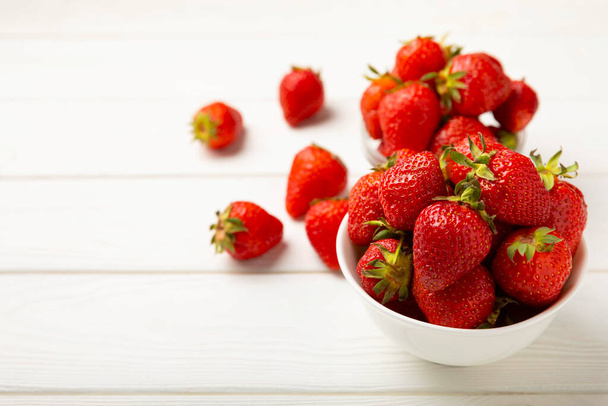 Fresh ripe strawberries in a plate on a white wooden background.Vegetarian organic berry.Healthy food.Vitamins.Copy space.Space for text - Фото, зображення