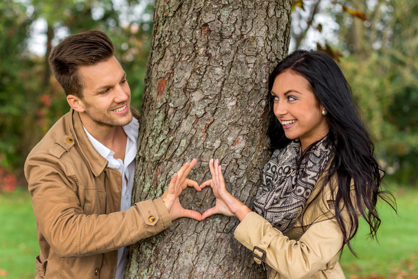 courting couple behind a tree - Foto, Imagen