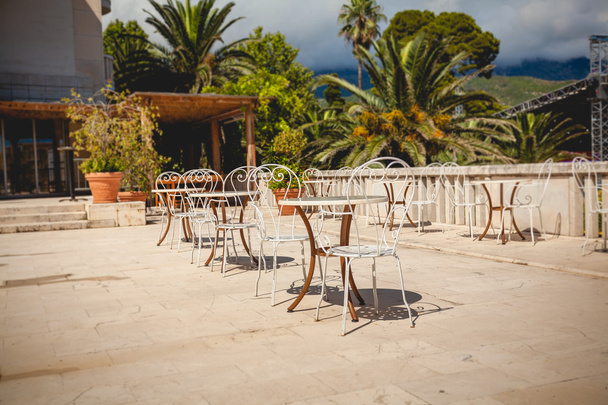 летняя терраса в ресторане в окружении зеленых пальм
 - Фото, изображение