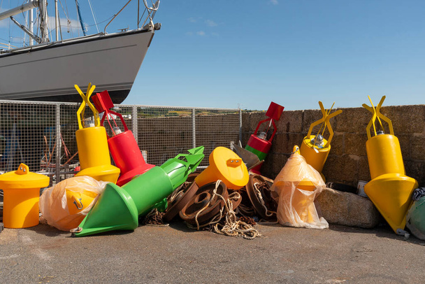 Penzance Harbour, Cornwall, Inglaterra, Reino Unido. 2022. Seleção colorida de bóias de plástico para ancoragem e navegação na parede do porto. Penzance, Cornwall, Reino Unido - Foto, Imagem