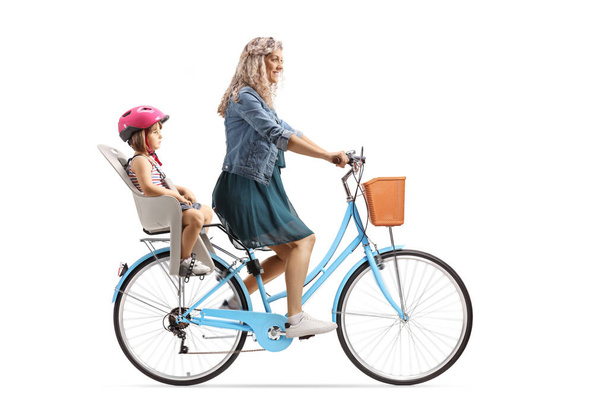 Mother riding a bicycle with a girl in a child seat isolated on white background - Zdjęcie, obraz